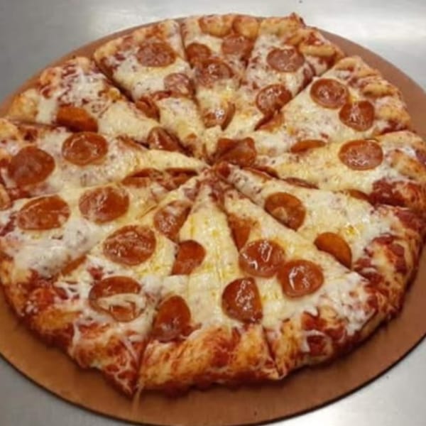 A freshly baked, sliced pepperoni pizza with melted cheese on a wooden pizza peel.
