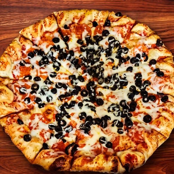 A whole pizza with tomato sauce, melted cheese, and black olives on a wooden surface.